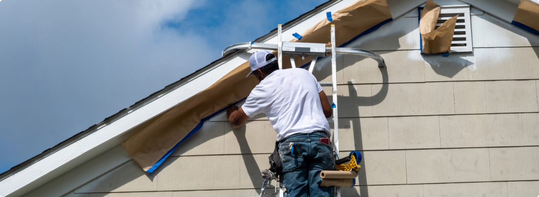 Construction worker assemble a suspended ceiling with drywall and fixing the drywall to the ceiling metal frame with screwdriver. Renovation, construction and ceiling installation concept.