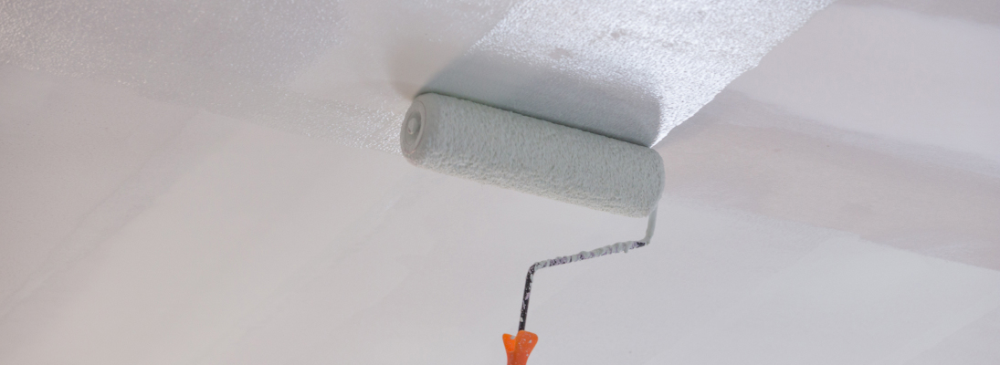 Construction worker assemble a suspended ceiling with drywall and fixing the drywall to the ceiling metal frame with screwdriver. Renovation, construction and ceiling installation concept.