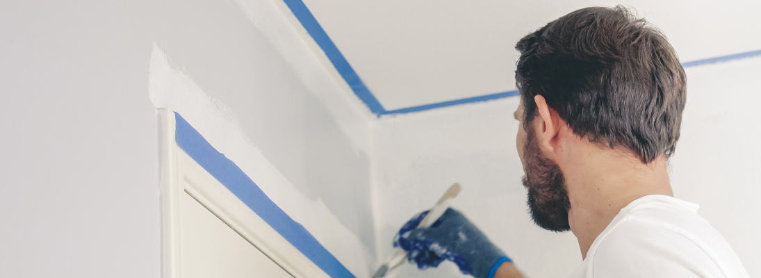 Construction worker assemble a suspended ceiling with drywall and fixing the drywall to the ceiling metal frame with screwdriver. Renovation, construction and ceiling installation concept.