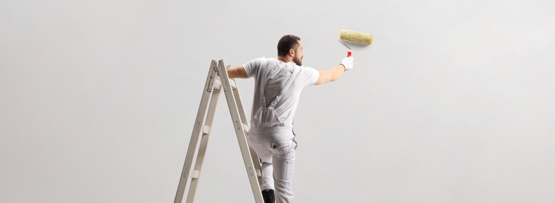 Construction worker assemble a suspended ceiling with drywall and fixing the drywall to the ceiling metal frame with screwdriver. Renovation, construction and ceiling installation concept.