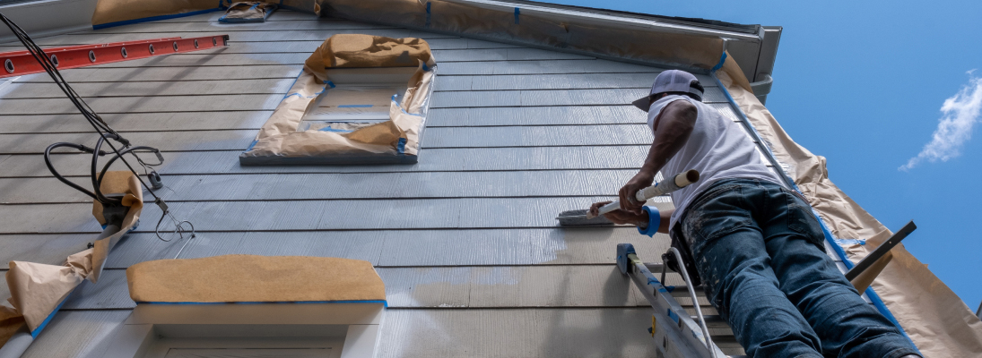 Construction worker assemble a suspended ceiling with drywall and fixing the drywall to the ceiling metal frame with screwdriver. Renovation, construction and ceiling installation concept.