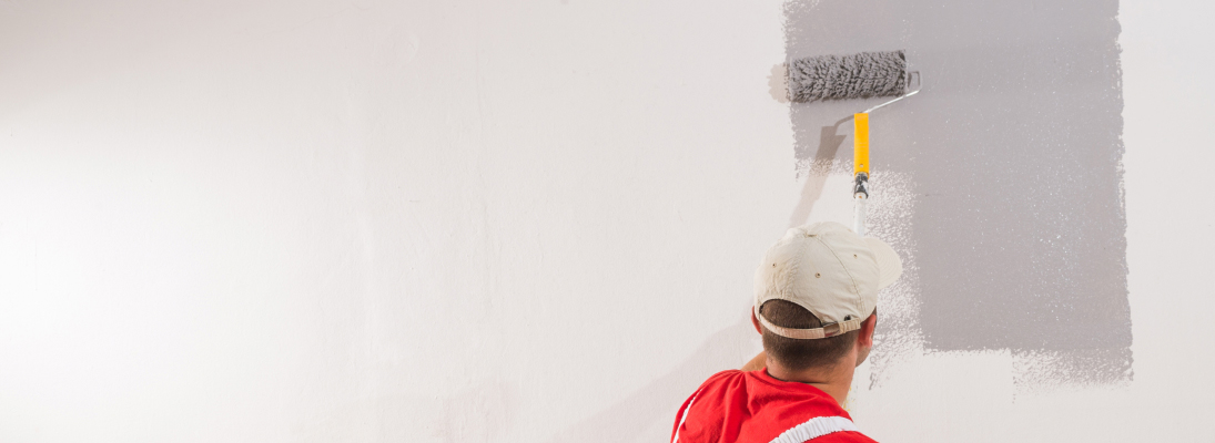 Construction worker assemble a suspended ceiling with drywall and fixing the drywall to the ceiling metal frame with screwdriver. Renovation, construction and ceiling installation concept.