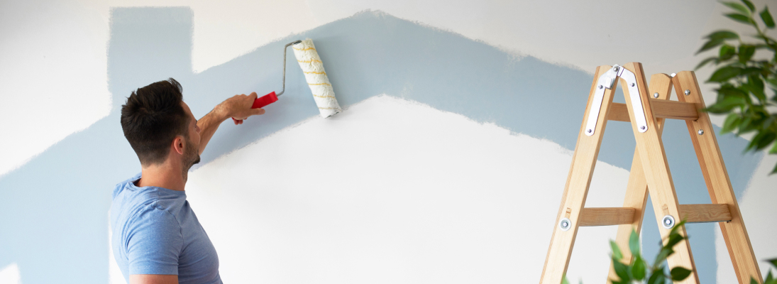 Construction worker assemble a suspended ceiling with drywall and fixing the drywall to the ceiling metal frame with screwdriver. Renovation, construction and ceiling installation concept.