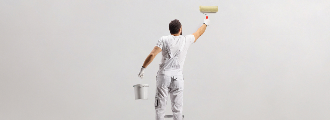 Construction worker assemble a suspended ceiling with drywall and fixing the drywall to the ceiling metal frame with screwdriver. Renovation, construction and ceiling installation concept.