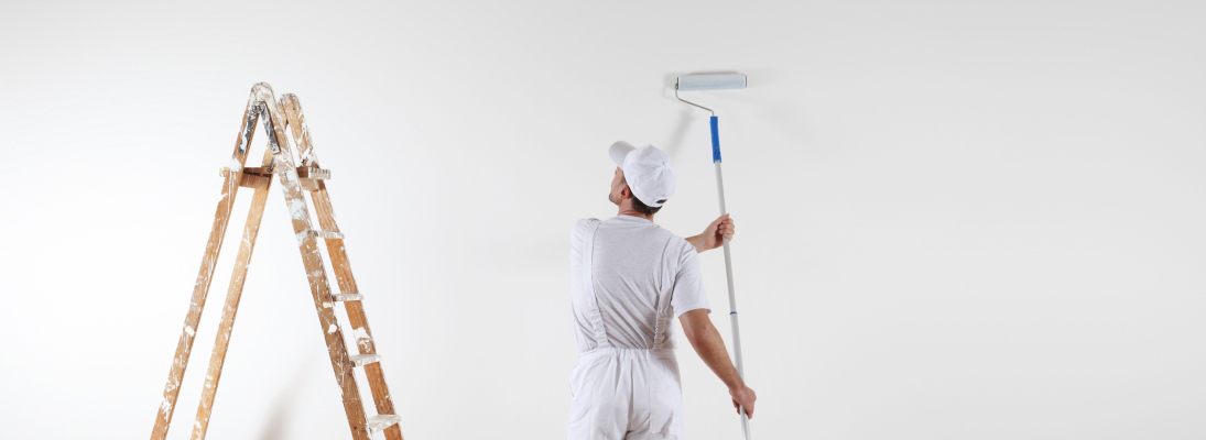 Construction worker assemble a suspended ceiling with drywall and fixing the drywall to the ceiling metal frame with screwdriver. Renovation, construction and ceiling installation concept.