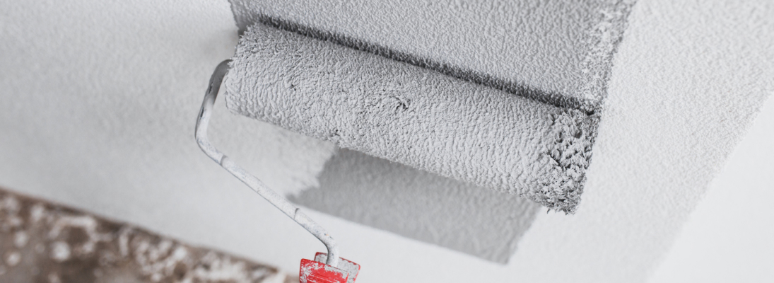 Construction worker assemble a suspended ceiling with drywall and fixing the drywall to the ceiling metal frame with screwdriver. Renovation, construction and ceiling installation concept.