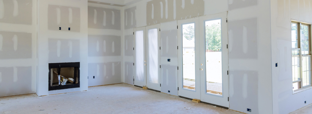 Construction worker assemble a suspended ceiling with drywall and fixing the drywall to the ceiling metal frame with screwdriver. Renovation, construction and ceiling installation concept.