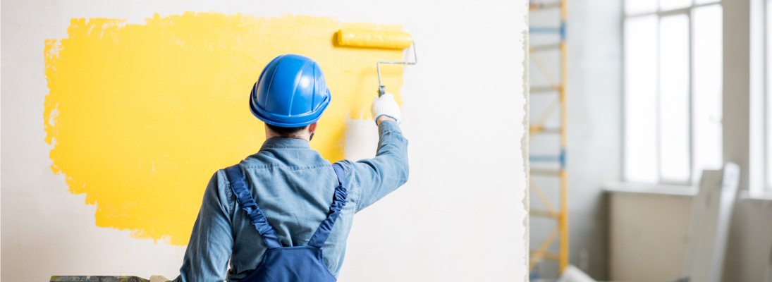 Construction worker assemble a suspended ceiling with drywall and fixing the drywall to the ceiling metal frame with screwdriver. Renovation, construction and ceiling installation concept.