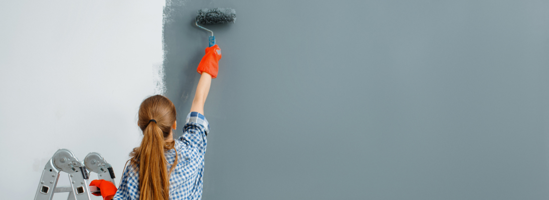 Construction worker assemble a suspended ceiling with drywall and fixing the drywall to the ceiling metal frame with screwdriver. Renovation, construction and ceiling installation concept.