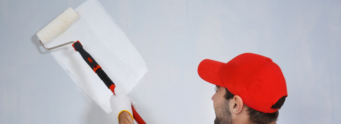 Construction worker assemble a suspended ceiling with drywall and fixing the drywall to the ceiling metal frame with screwdriver. Renovation, construction and ceiling installation concept.