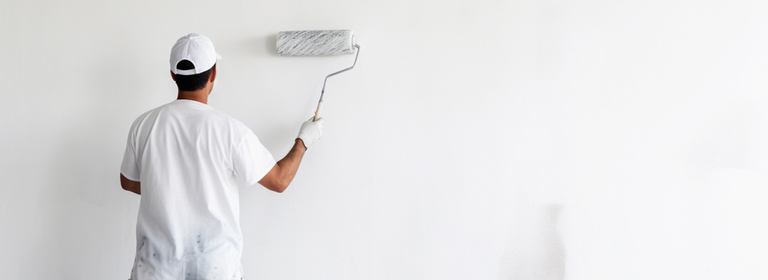 Construction worker assemble a suspended ceiling with drywall and fixing the drywall to the ceiling metal frame with screwdriver. Renovation, construction and ceiling installation concept.