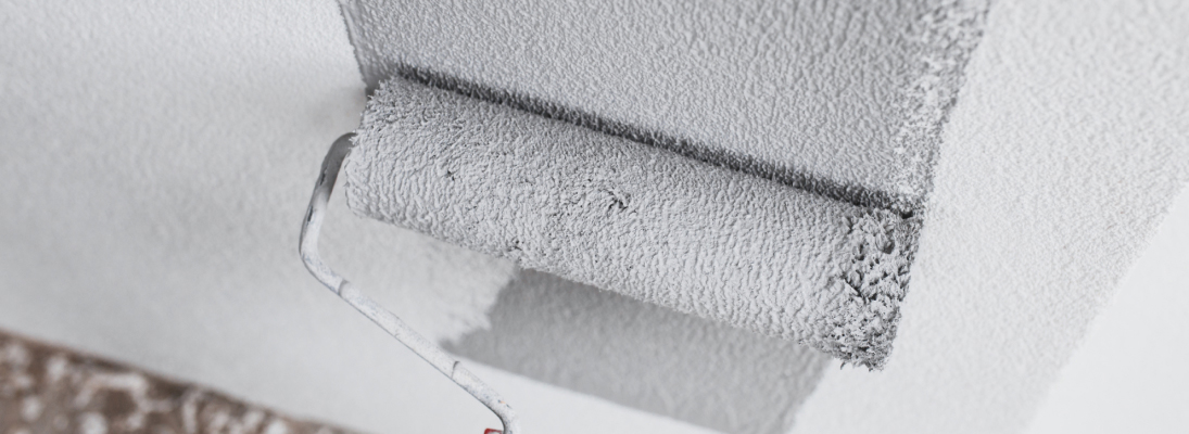 Construction worker assemble a suspended ceiling with drywall and fixing the drywall to the ceiling metal frame with screwdriver. Renovation, construction and ceiling installation concept.