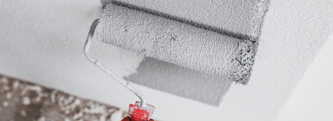 Construction worker assemble a suspended ceiling with drywall and fixing the drywall to the ceiling metal frame with screwdriver. Renovation, construction and ceiling installation concept.