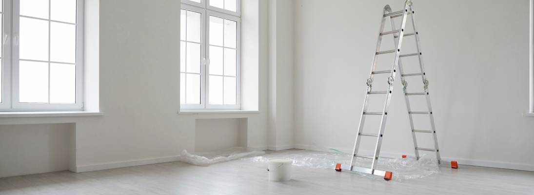 Construction worker assemble a suspended ceiling with drywall and fixing the drywall to the ceiling metal frame with screwdriver. Renovation, construction and ceiling installation concept.