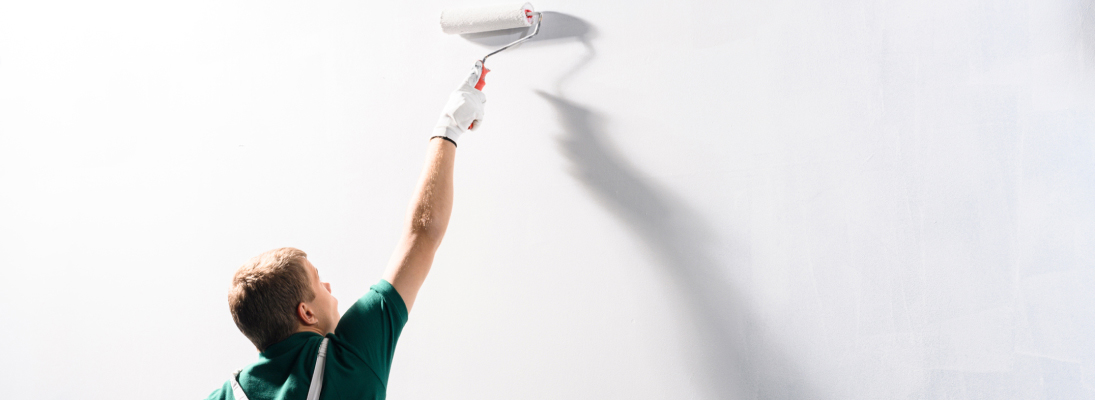 Construction worker assemble a suspended ceiling with drywall and fixing the drywall to the ceiling metal frame with screwdriver. Renovation, construction and ceiling installation concept.