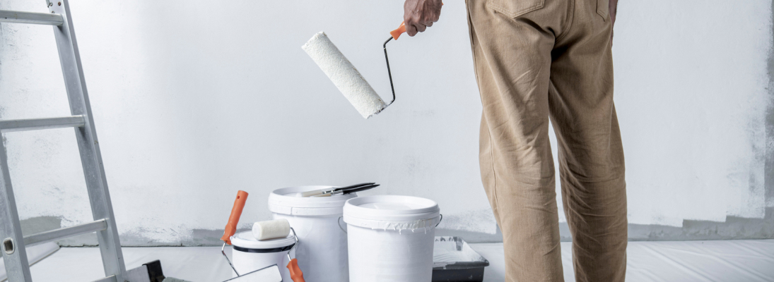 Construction worker assemble a suspended ceiling with drywall and fixing the drywall to the ceiling metal frame with screwdriver. Renovation, construction and ceiling installation concept.