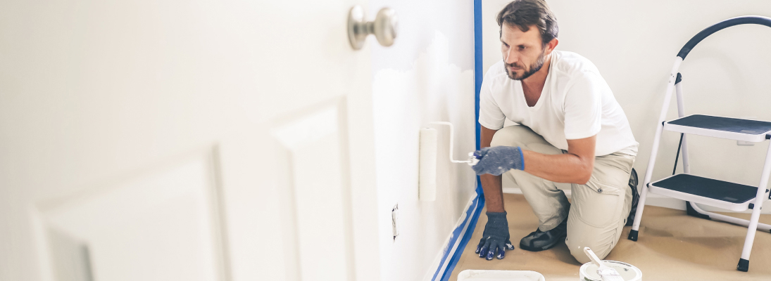 Construction worker assemble a suspended ceiling with drywall and fixing the drywall to the ceiling metal frame with screwdriver. Renovation, construction and ceiling installation concept.