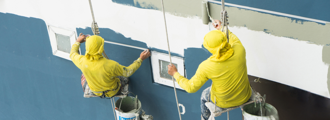 Construction worker assemble a suspended ceiling with drywall and fixing the drywall to the ceiling metal frame with screwdriver. Renovation, construction and ceiling installation concept.