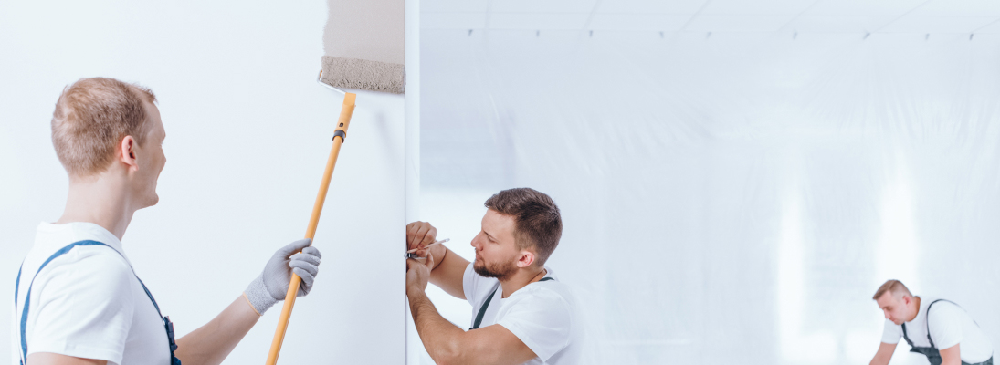 Construction worker assemble a suspended ceiling with drywall and fixing the drywall to the ceiling metal frame with screwdriver. Renovation, construction and ceiling installation concept.