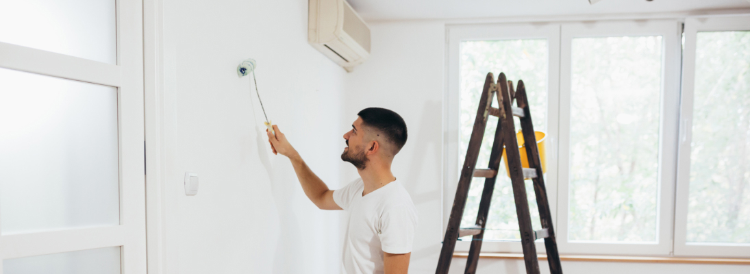 Construction worker assemble a suspended ceiling with drywall and fixing the drywall to the ceiling metal frame with screwdriver. Renovation, construction and ceiling installation concept.