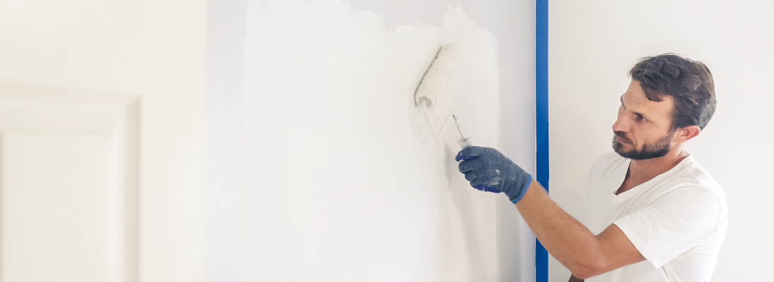 Construction worker assemble a suspended ceiling with drywall and fixing the drywall to the ceiling metal frame with screwdriver. Renovation, construction and ceiling installation concept.