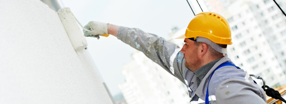 Construction worker assemble a suspended ceiling with drywall and fixing the drywall to the ceiling metal frame with screwdriver. Renovation, construction and ceiling installation concept.