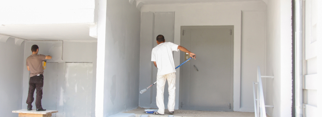 Construction worker assemble a suspended ceiling with drywall and fixing the drywall to the ceiling metal frame with screwdriver. Renovation, construction and ceiling installation concept.