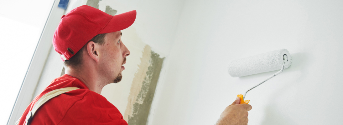 Construction worker assemble a suspended ceiling with drywall and fixing the drywall to the ceiling metal frame with screwdriver. Renovation, construction and ceiling installation concept.