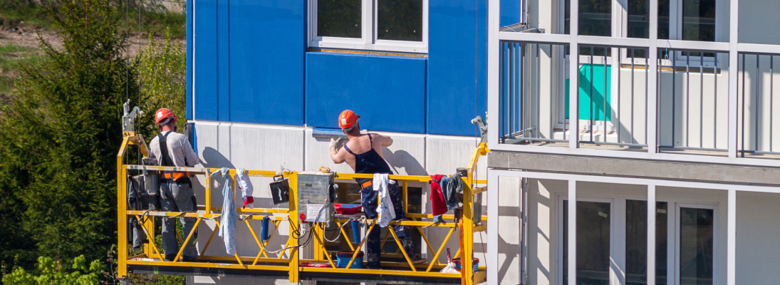 Construction worker assemble a suspended ceiling with drywall and fixing the drywall to the ceiling metal frame with screwdriver. Renovation, construction and ceiling installation concept.