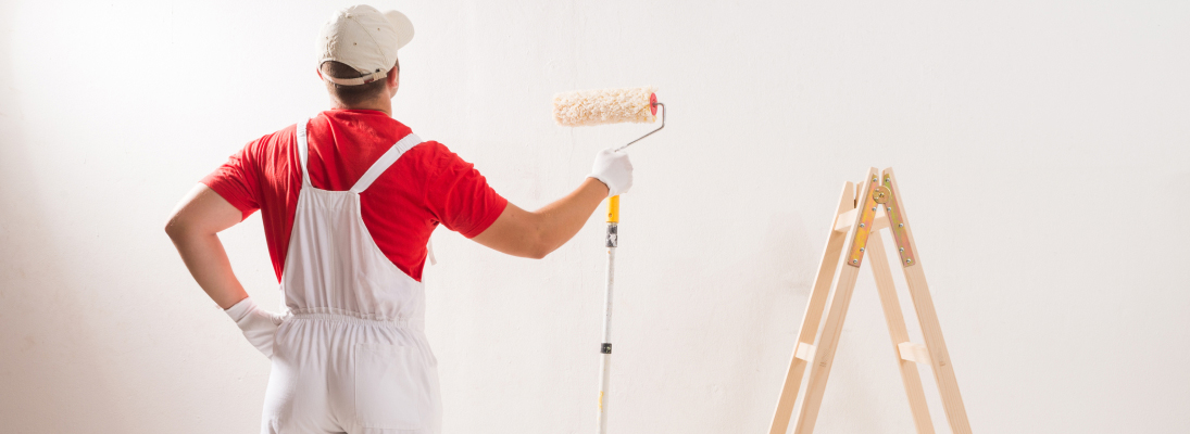 Construction worker assemble a suspended ceiling with drywall and fixing the drywall to the ceiling metal frame with screwdriver. Renovation, construction and ceiling installation concept.