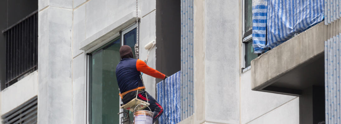 Construction worker assemble a suspended ceiling with drywall and fixing the drywall to the ceiling metal frame with screwdriver. Renovation, construction and ceiling installation concept.