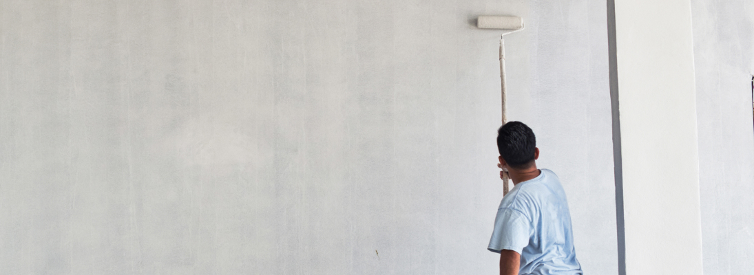 Construction worker assemble a suspended ceiling with drywall and fixing the drywall to the ceiling metal frame with screwdriver. Renovation, construction and ceiling installation concept.