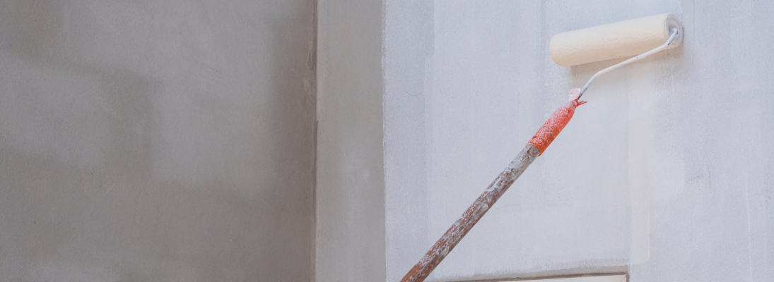 Construction worker assemble a suspended ceiling with drywall and fixing the drywall to the ceiling metal frame with screwdriver. Renovation, construction and ceiling installation concept.