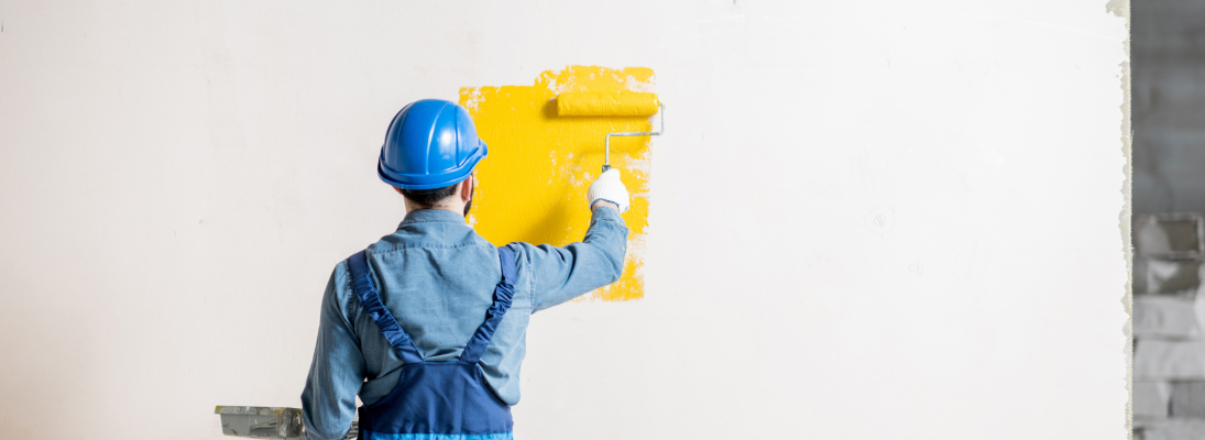 Construction worker assemble a suspended ceiling with drywall and fixing the drywall to the ceiling metal frame with screwdriver. Renovation, construction and ceiling installation concept.