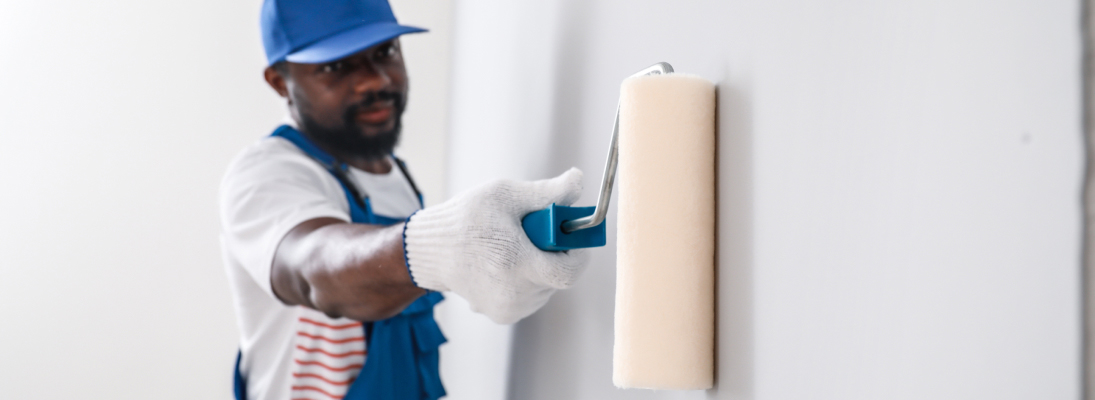 Construction worker assemble a suspended ceiling with drywall and fixing the drywall to the ceiling metal frame with screwdriver. Renovation, construction and ceiling installation concept.