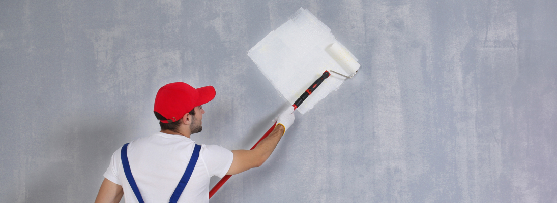 Construction worker assemble a suspended ceiling with drywall and fixing the drywall to the ceiling metal frame with screwdriver. Renovation, construction and ceiling installation concept.