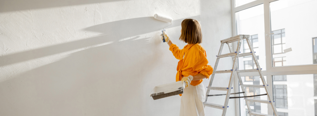 Construction worker assemble a suspended ceiling with drywall and fixing the drywall to the ceiling metal frame with screwdriver. Renovation, construction and ceiling installation concept.