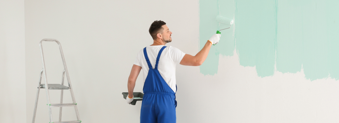 Construction worker assemble a suspended ceiling with drywall and fixing the drywall to the ceiling metal frame with screwdriver. Renovation, construction and ceiling installation concept.