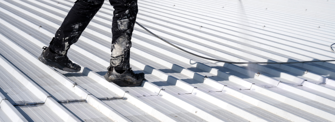 Construction worker assemble a suspended ceiling with drywall and fixing the drywall to the ceiling metal frame with screwdriver. Renovation, construction and ceiling installation concept.