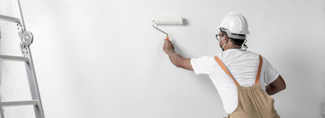 Construction worker assemble a suspended ceiling with drywall and fixing the drywall to the ceiling metal frame with screwdriver. Renovation, construction and ceiling installation concept.