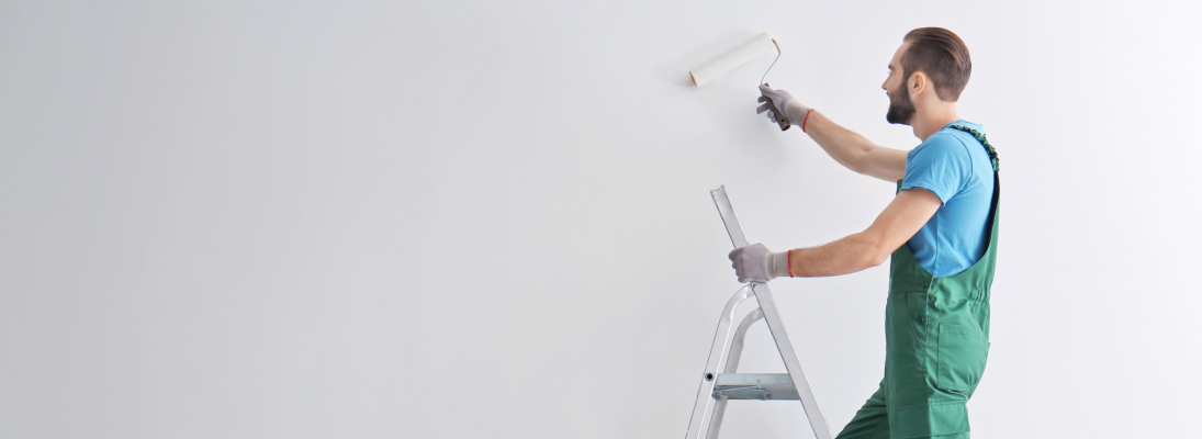 Construction worker assemble a suspended ceiling with drywall and fixing the drywall to the ceiling metal frame with screwdriver. Renovation, construction and ceiling installation concept.