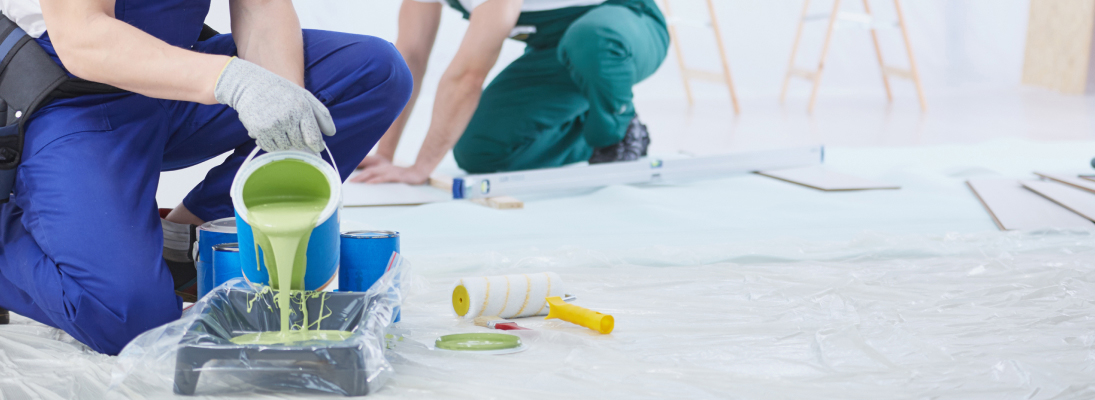 Construction worker assemble a suspended ceiling with drywall and fixing the drywall to the ceiling metal frame with screwdriver. Renovation, construction and ceiling installation concept.