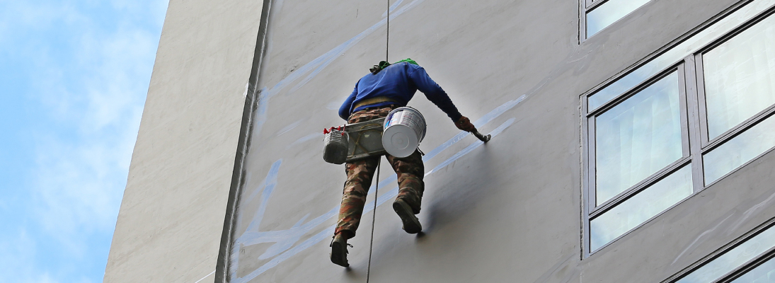 Construction worker assemble a suspended ceiling with drywall and fixing the drywall to the ceiling metal frame with screwdriver. Renovation, construction and ceiling installation concept.