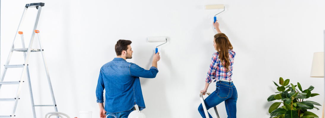 Construction worker assemble a suspended ceiling with drywall and fixing the drywall to the ceiling metal frame with screwdriver. Renovation, construction and ceiling installation concept.