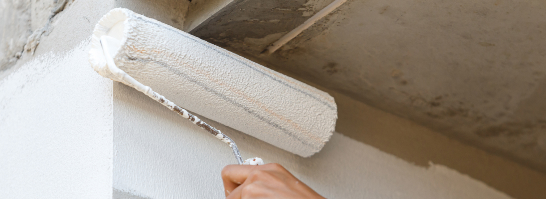 Construction worker assemble a suspended ceiling with drywall and fixing the drywall to the ceiling metal frame with screwdriver. Renovation, construction and ceiling installation concept.