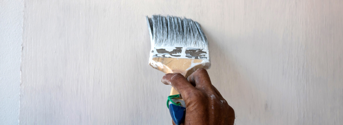 Construction worker assemble a suspended ceiling with drywall and fixing the drywall to the ceiling metal frame with screwdriver. Renovation, construction and ceiling installation concept.