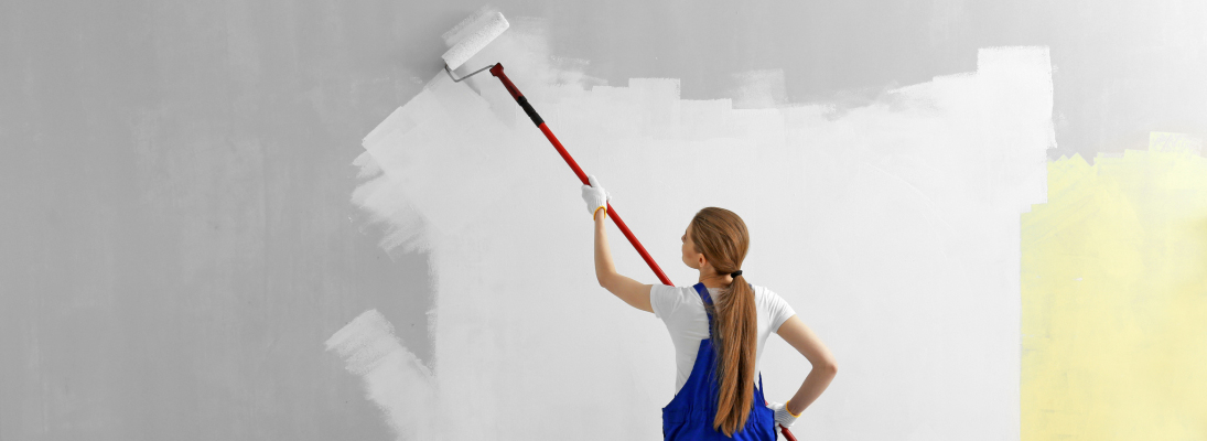 Construction worker assemble a suspended ceiling with drywall and fixing the drywall to the ceiling metal frame with screwdriver. Renovation, construction and ceiling installation concept.