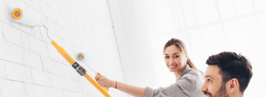 Construction worker assemble a suspended ceiling with drywall and fixing the drywall to the ceiling metal frame with screwdriver. Renovation, construction and ceiling installation concept.