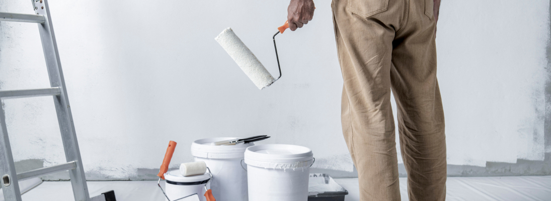 Construction worker assemble a suspended ceiling with drywall and fixing the drywall to the ceiling metal frame with screwdriver. Renovation, construction and ceiling installation concept.