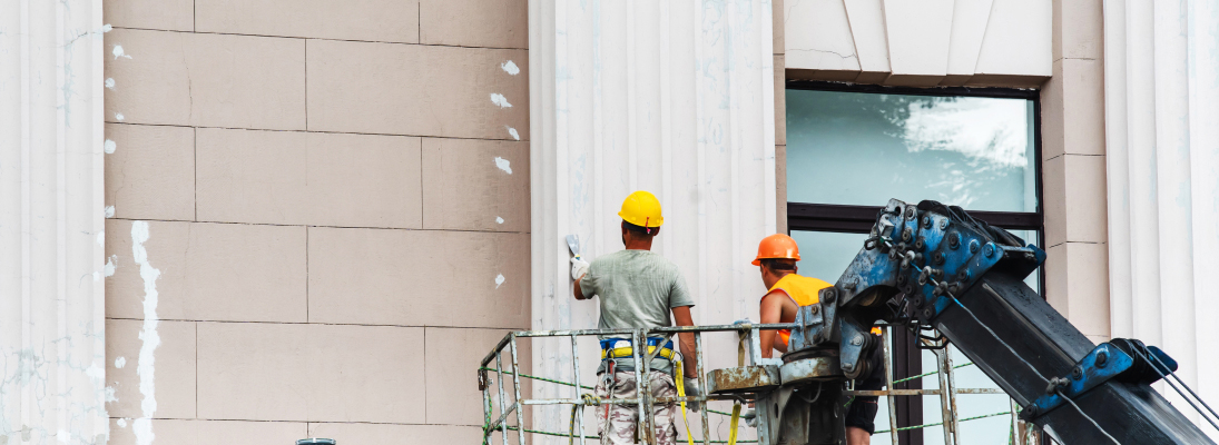 Construction worker assemble a suspended ceiling with drywall and fixing the drywall to the ceiling metal frame with screwdriver. Renovation, construction and ceiling installation concept.